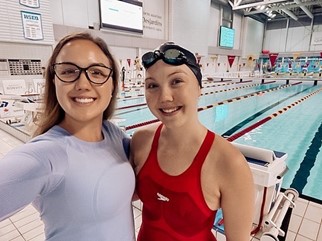 A couple of women posing for a picture next to a swimming poolDescription automatically generated with low confidence